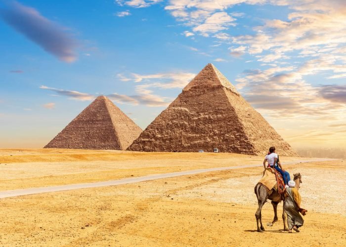 Les Touristes Montent Un Chameau Devant Les Pyramides De Guizeh